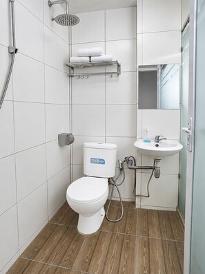 A modern bathroom with a toilet, shower, and sink.
