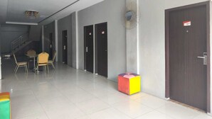 A hotel lobby with a staircase, a reception desk, and a colorful cube sculpture. - Collection O near Lampung City Mall formerly Royal Guesthouse (Bandar Lampung)