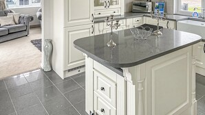 A modern kitchen with white cabinetry, a granite countertop, and a built-in oven.
