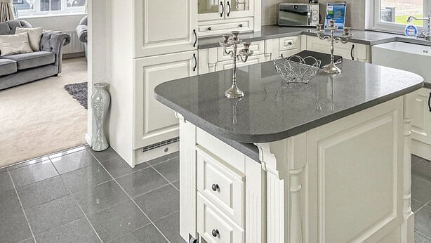 A modern kitchen with white cabinetry, a granite countertop, and a built-in oven. - 2 bedroom accommodation in Laurenkirk (Laurenkirk)
