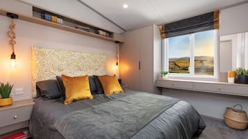 Une chambre moderne comprenant un lit, des tables de chevet, une tête de lit à motifs texturés, une fenêtre avec vue et des étagères intégrées.