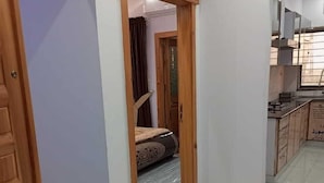 A hallway leading to a bedroom with a bed and a bathroom. - Al Rehman Palace 1 (Lahore)