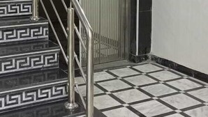 A staircase with a geometric pattern leading to a modern elevator with a decorative panel. - Al Rehman Palace 1 (Lahore)