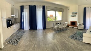 Ein moderner Wohnraum mit Küche, Essbereich und Sitzgelegenheit.