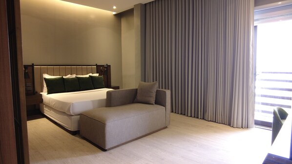 Relax in a spacious room with a large bed, sofa, and floor-to-ceiling window.
