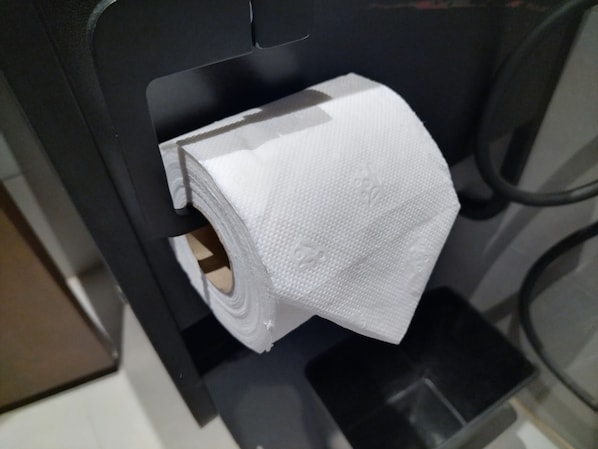 Un rollo de papel higiénico sujeto a un portalápices negro.