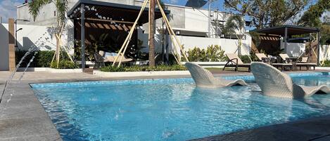 Una piscina con una tumbona con forma de ballena.