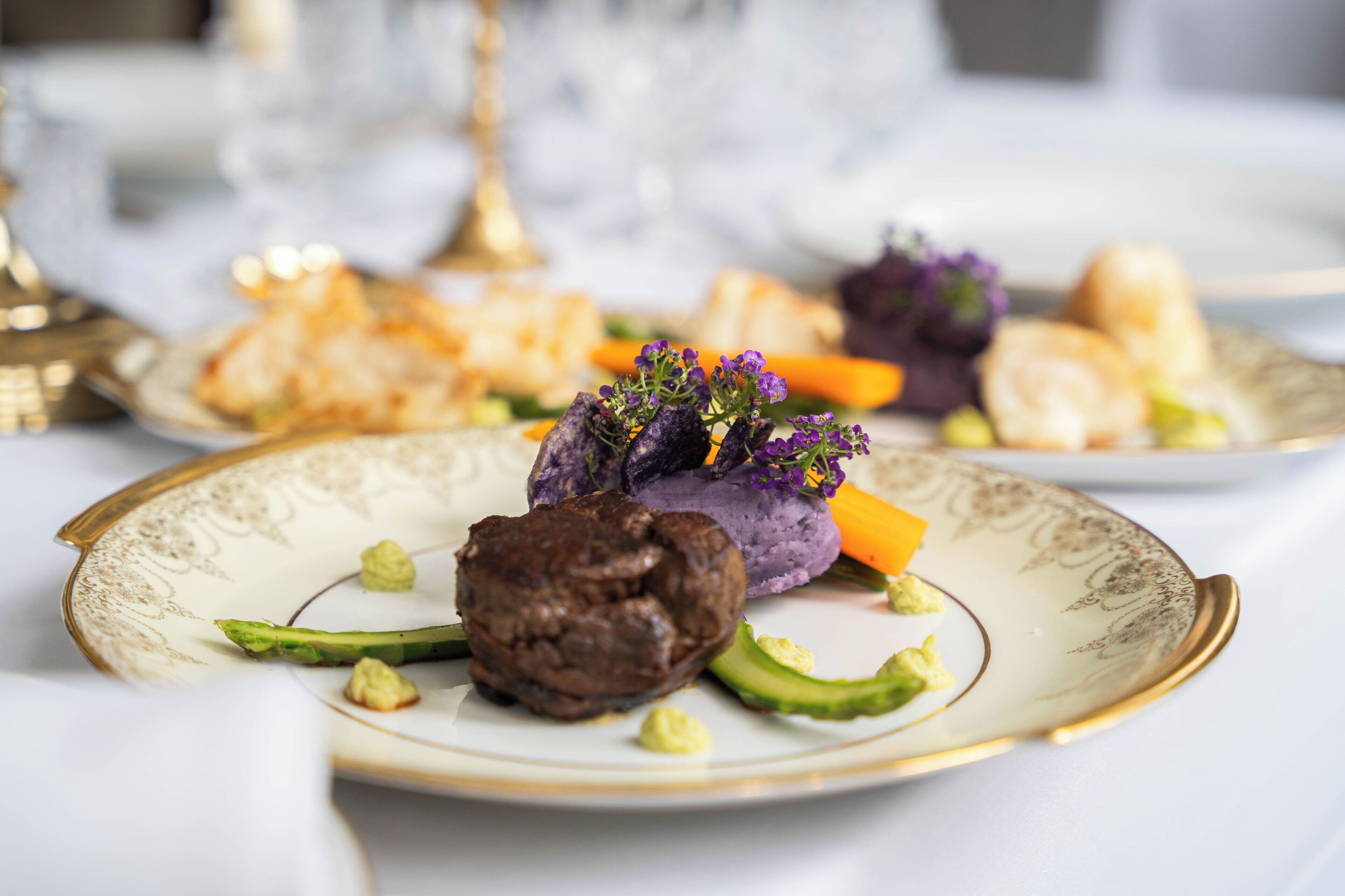 Un plato con postre de chocolate, comida morada y verduras verdes.