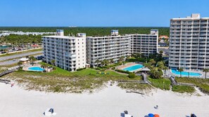 A beachfront hotel with multiple floors, a pool area, and a beach. - Seaside Orange Beach, Indoor Pool, Tennis Courts! (Orange Beach)