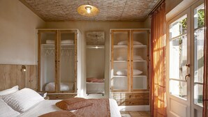 Une chambre à coucher avec un lit, une armoire et une porte donnant sur une vue agréable.