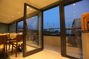 Un comedor moderno con vistas a una mezquita a través de amplios ventanales.