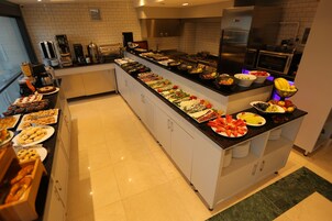 Un bufé con diferentes opciones de comida y una estación de café.