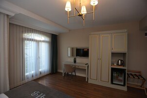 Un dormitorio moderno con escritorio, televisor y armario.