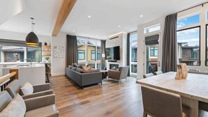 Een moderne woonkamer met een bank, stoelen en een eettafel.