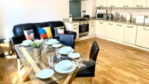 A modern kitchen with a gas stove, microwave, and white cabinets. - Sight Flat - SF01 - One Bedroom Flat (London)