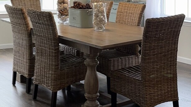 A dining room with a round table, wicker chairs, a hanging light fixture, and a mirror on the wall. - Cozy New Home, Close to Beaches, Restaurants and Bike Trials, Free EV charging  (Rehoboth Beach)