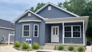A two-story house with a front porch, a garage, and a driveway. - Cozy New Home, Close to Beaches, Restaurants and Bike Trials, Free EV charging  (Rehoboth Beach)