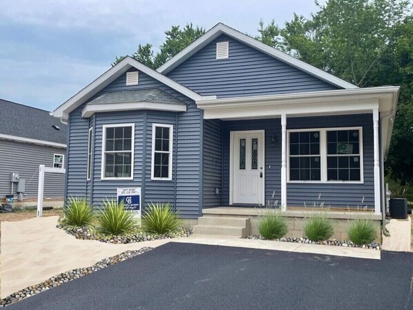 A two-story house with a front porch, a garage, and a driveway.