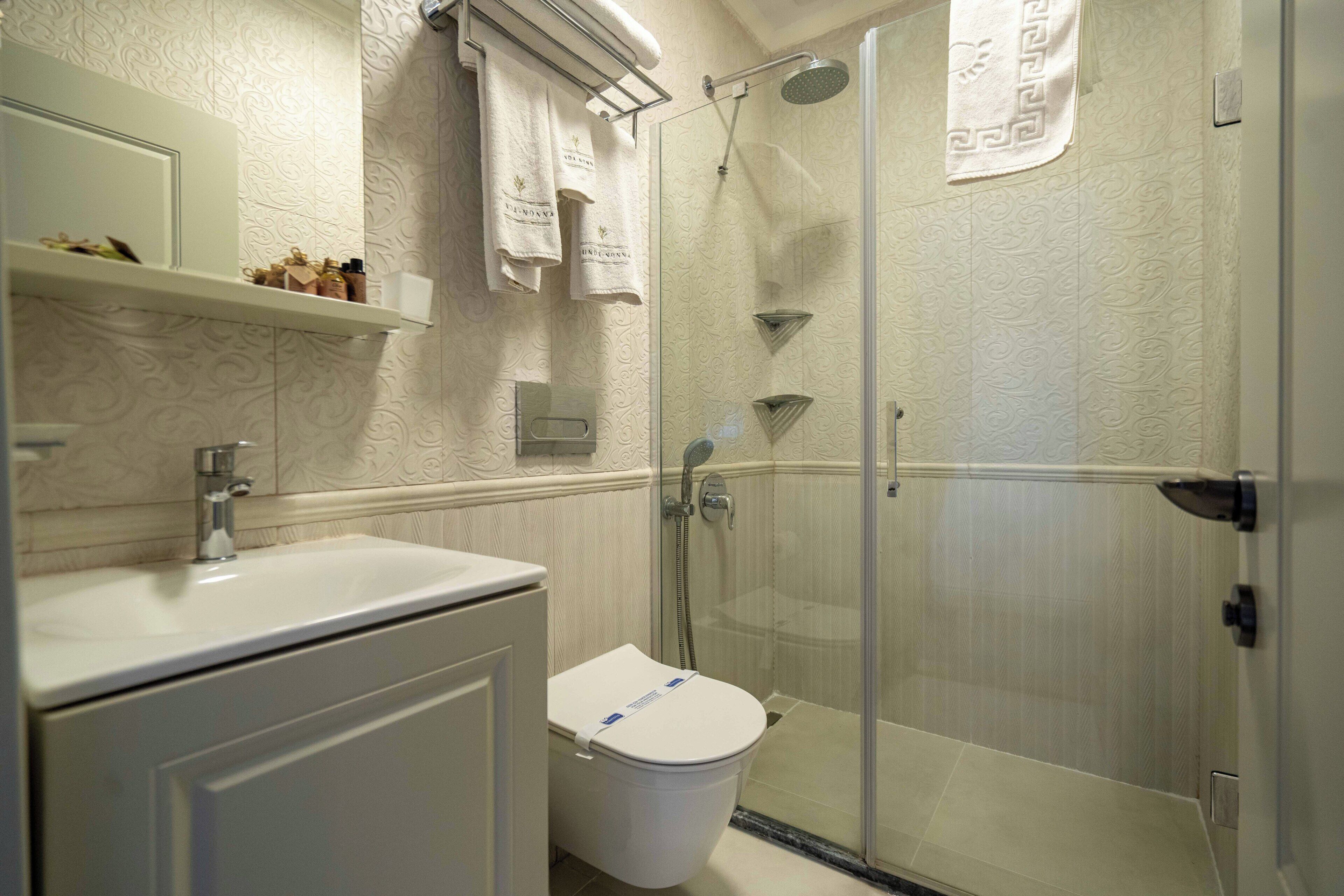 Un baño con inodoro, lavamanos y ducha.