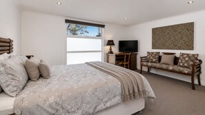 Ein Schlafzimmer mit einem Bett, einem Sofa, einem Fernseher und einem Fenster.