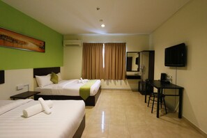 Una habitación de hotel con dos camas, un escritorio, una silla, un televisor y un cuadro en la pared.