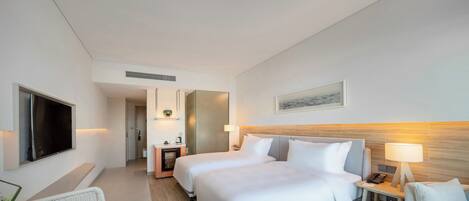 A hotel room with a large bed, a TV, a desk, and a chair.