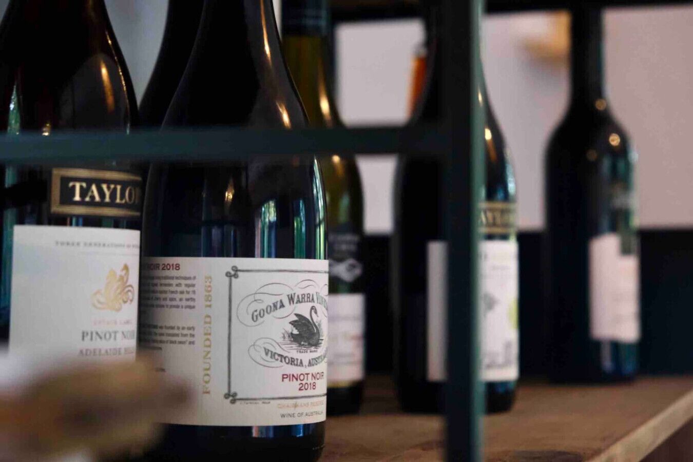 Una selezione di bottiglie di vino su una mensola.