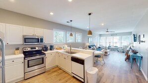 A modern kitchen with white cabinets, stainless steel appliances, and a central island.