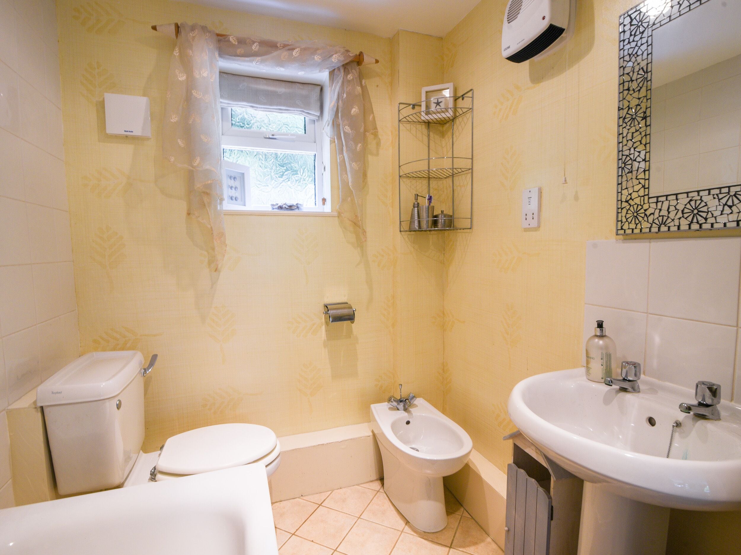Un baño con inodoro, bidé y lavamanos.