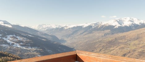 Un paisaje montañoso con picos nevados y cielo despejado.