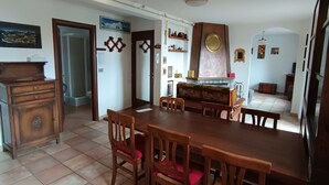 A dining area with a wooden table and chairs, a built-in bench, and a decorative wall unit.