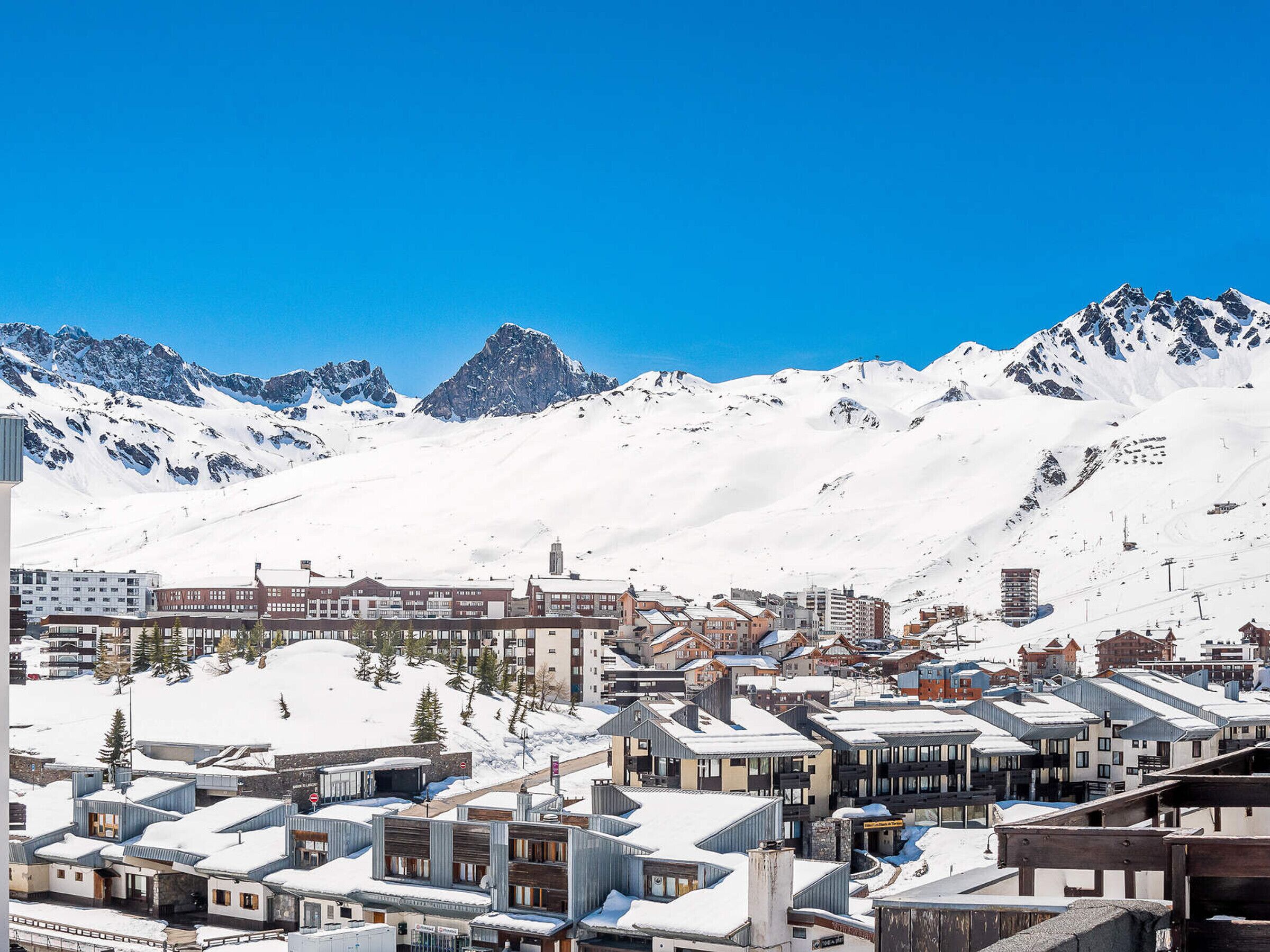 A snow-covered town with buildings and mountains in the background.
