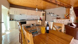 Une cuisine chaleureuse avec des meubles en bois, un dosseret carrelé et un mur d’accent en pierre.