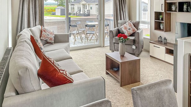 A modern living room with a sofa, armchairs, a coffee table, and a TV stand. - 1 bedroom accommodation in Laurenkirk (Laurenkirk)