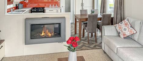 Un espacio habitable pequeño con chimenea, comedor y kitchenette.