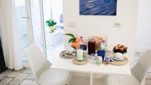 A dining table with a painting, food, and drinks. - Suite Saint Michael (Capri)