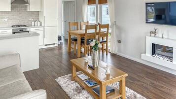 A modern kitchen with white cabinets, a gas stove, and a built-in oven.