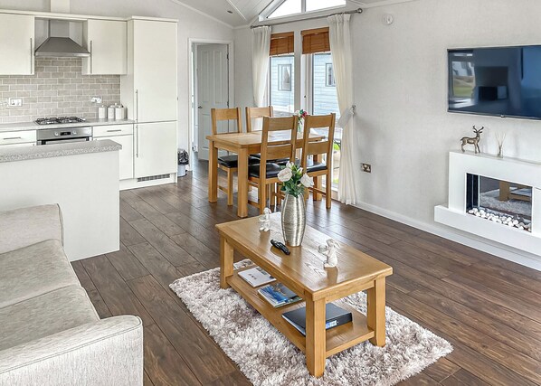 A modern kitchen with white cabinets, a gas stove, and a built-in oven.