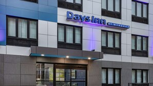 A Days Inn hotel with a modern facade, large windows, and a sign indicating its location on Wyndham Avenue. - Days Inn by Wyndham Bronx NYC (Bronx)
