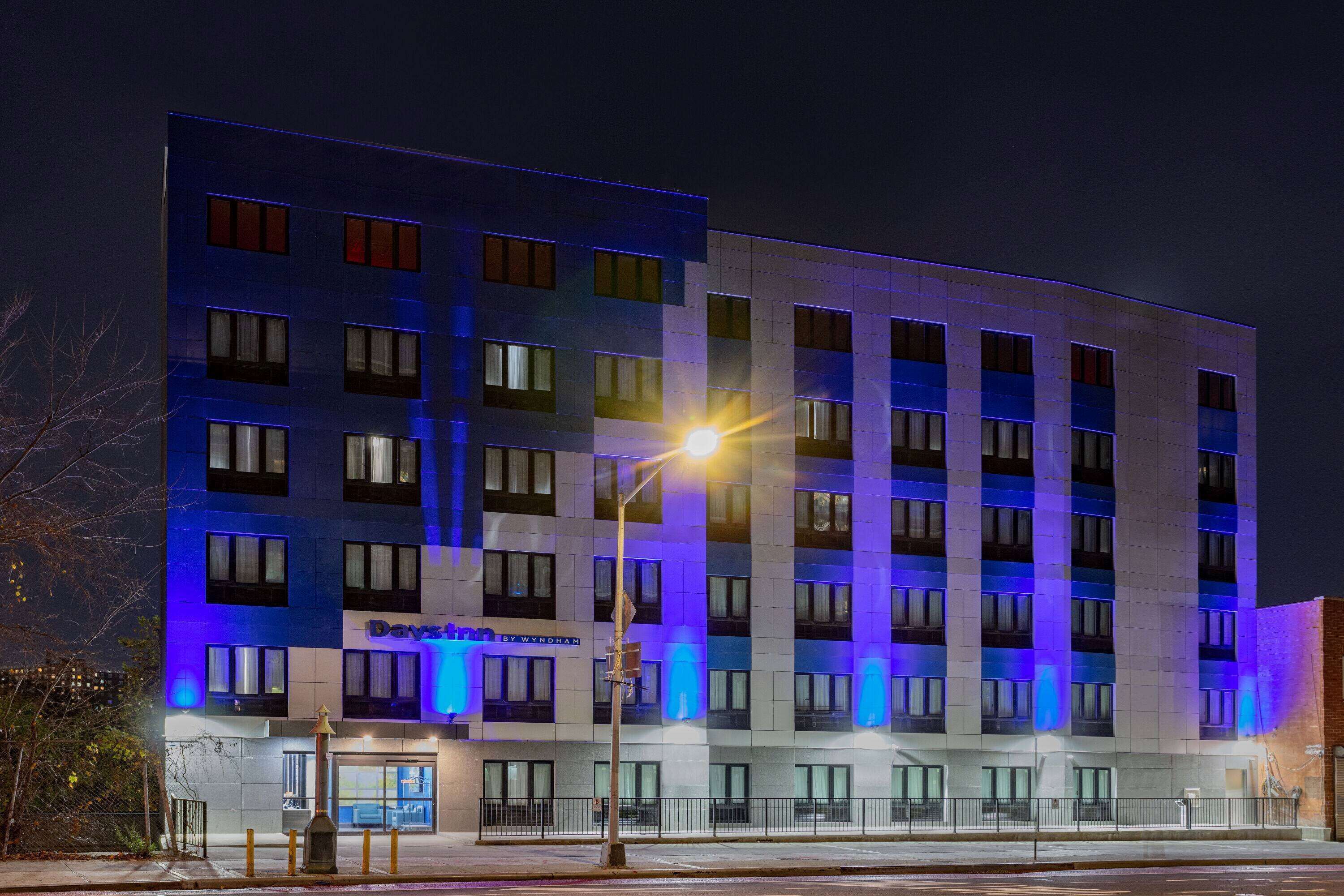 A multi-story hotel with a modern design, featuring a prominent entrance and a well-lit facade.