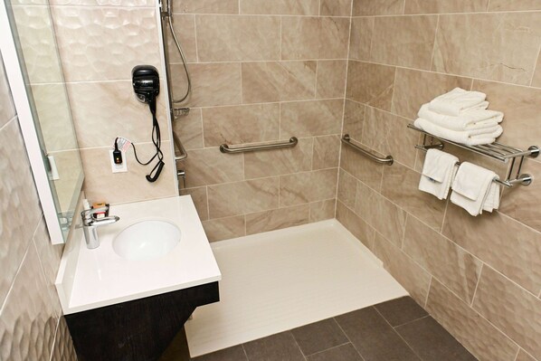 A modern bathroom with a sink, mirror, towel rack, and shower area. - Days Inn by Wyndham Bronx NYC (Bronx)