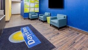 A reception area with blue walls, a mounted TV, and a reception desk. - Days Inn by Wyndham Bronx NYC (Bronx)