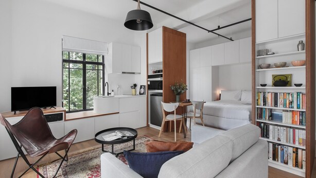 Un salon moderne avec un canapé, une table basse et une bibliothèque remplie de livres.