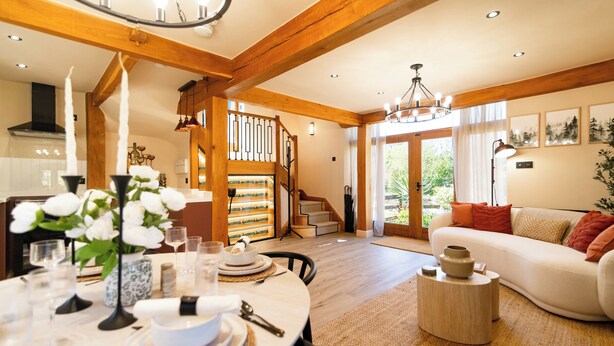 A spacious living area with a dining table set, a staircase, and a sofa. - Dovecote (Dover)