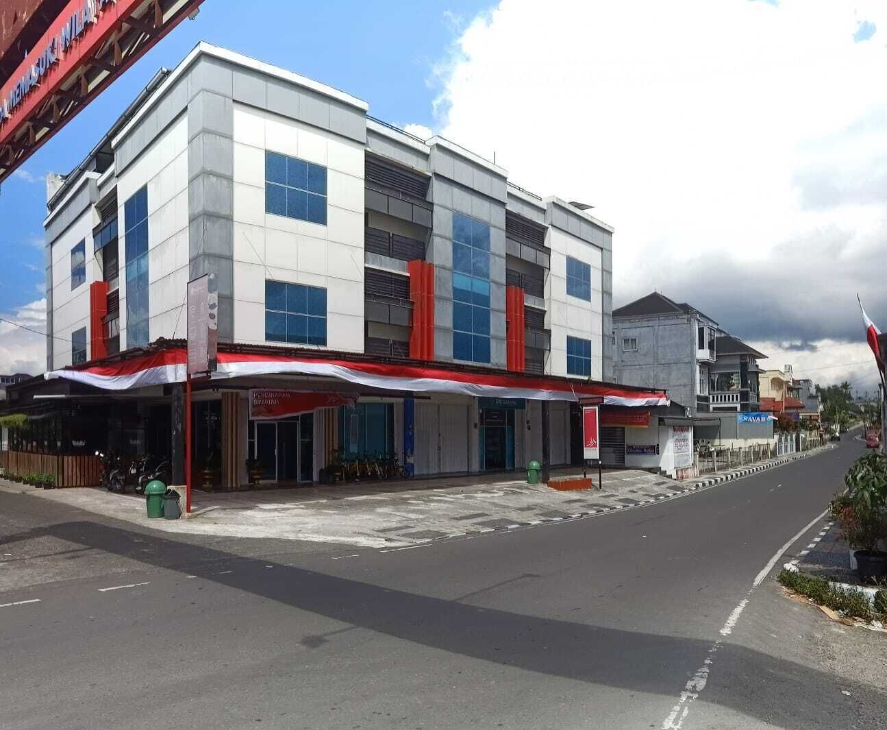 A multi-story building with a commercial ground floor featuring awnings and signage.