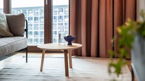 Ein modernes Wohnzimmer mit einer Couch, einem runden Holztisch und einer Obstschale.