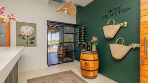 A modern interior with a wooden barrel, a wall-mounted wine rack, and a 'Picnic Collection' sign.