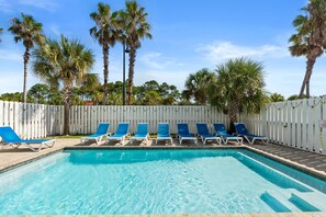 A swimming pool with blue lounge chairs and a white fence. - Just Beachy Private Pool! Just 20 Steps to the beach! Incredible Home (PANAMA CITY BEACH)