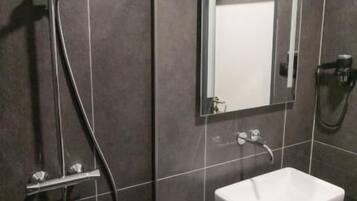 A modern bathroom with a shower, a sink, and a mirror.