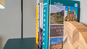 Una fila de libros en una estantería, incluyendo 'Collins Scrabble' y 'North York Pub Walks'.